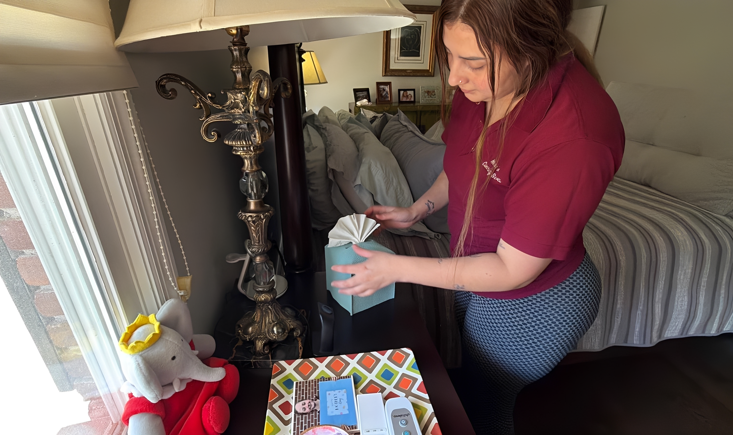Person arranging tissues on a bedside table.