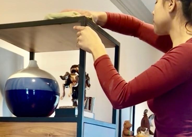 Person placing a blue glass orb inside a wooden frame.