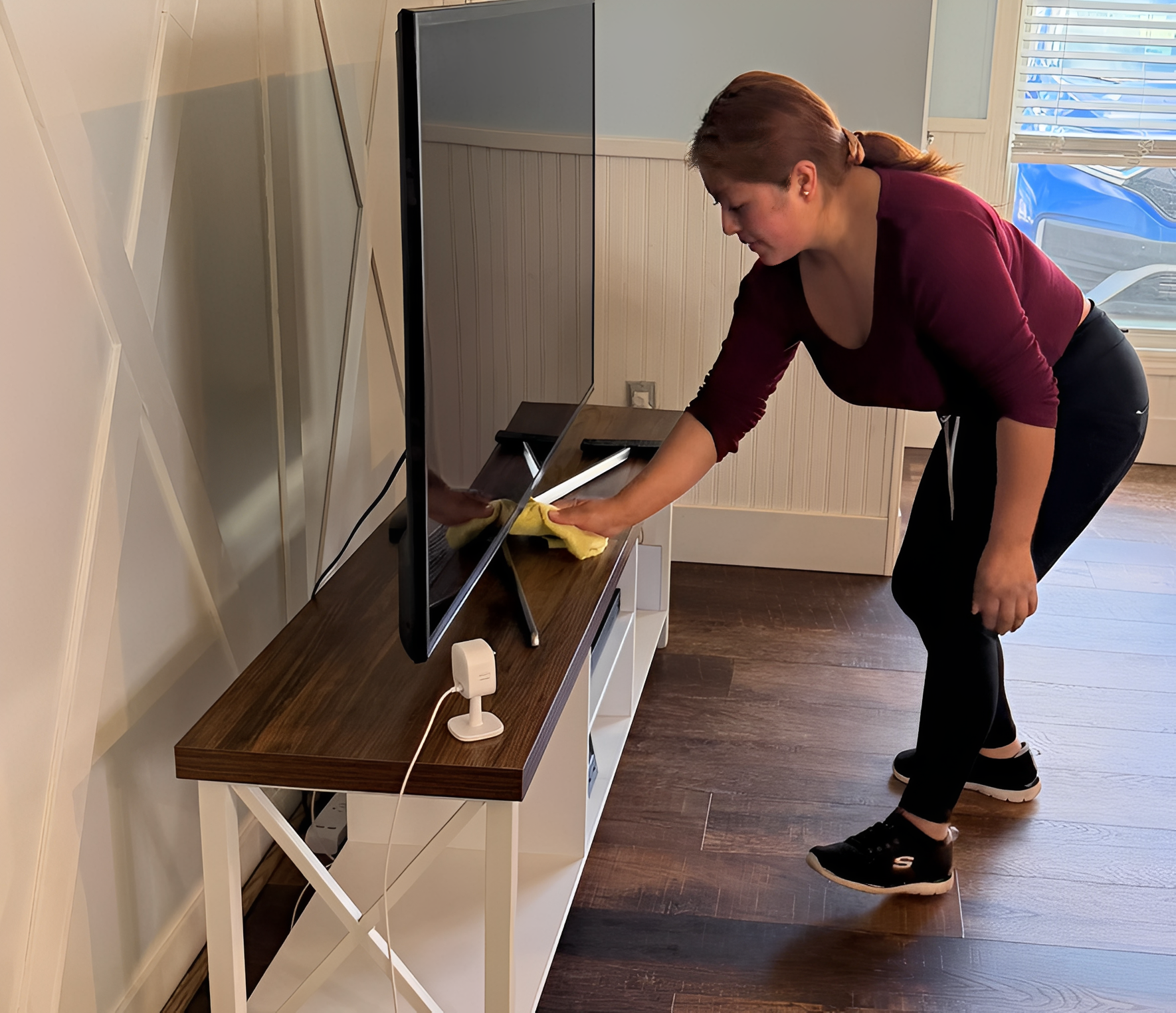 Person cleaning a flat-screen TV.