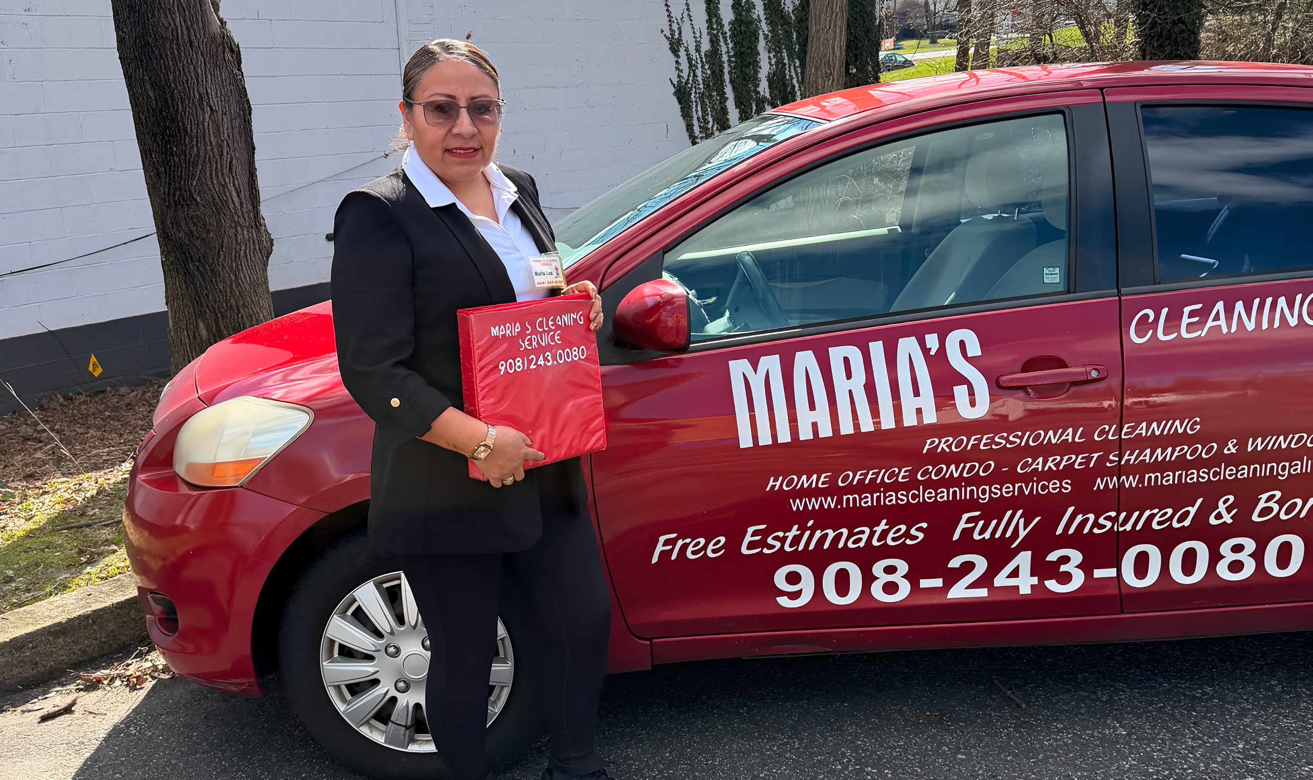 Woman standing by red cleaning service car.