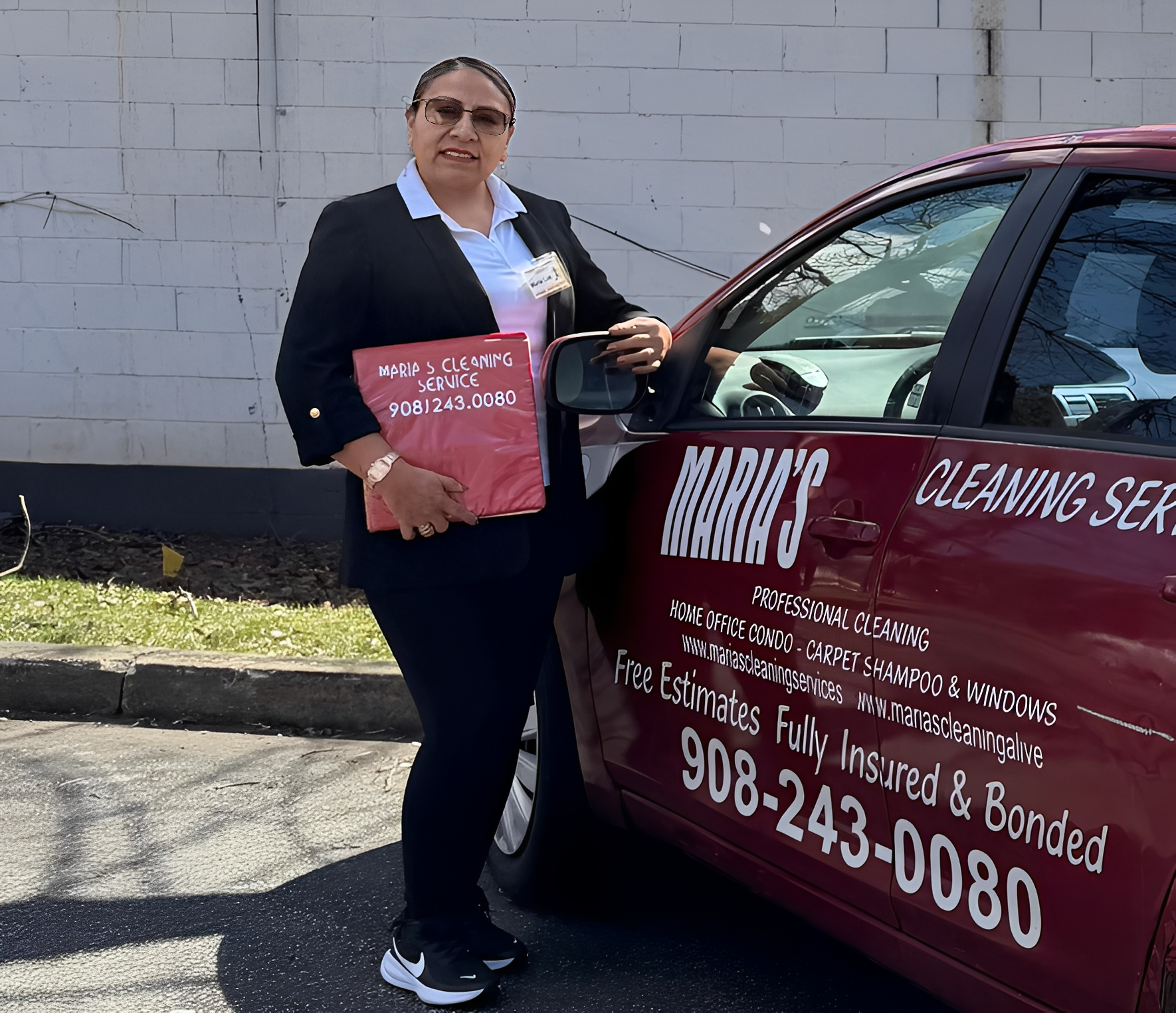 Woman standing next to cleaning service car.